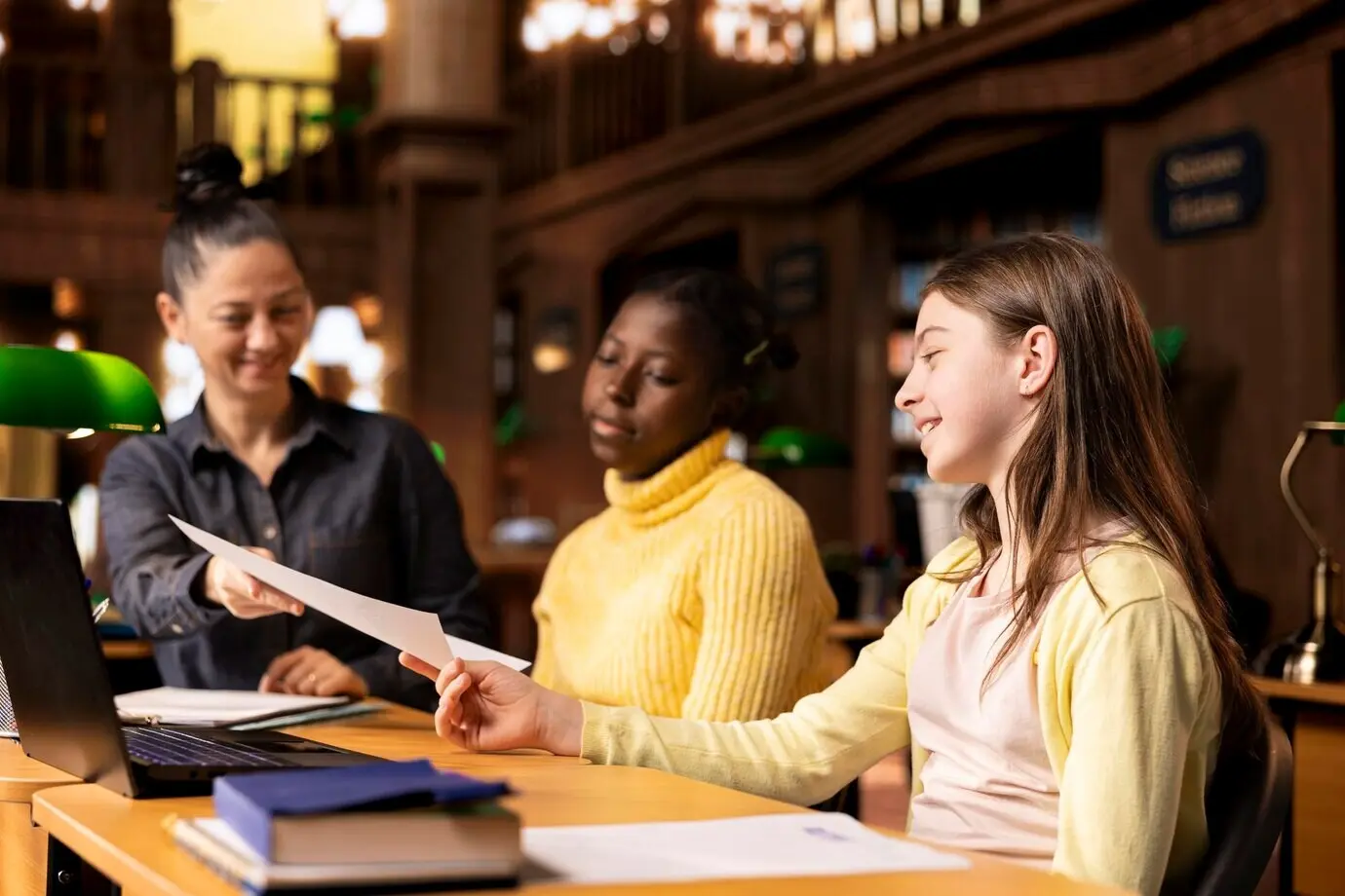 Репетитор предоставляет учебные материалы во время учебного занятия со школьницами.